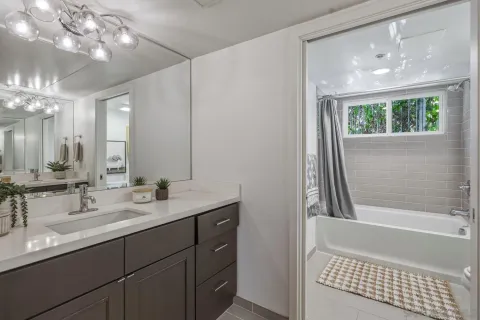 a bedroom with a bed a flat screen tv and a large window