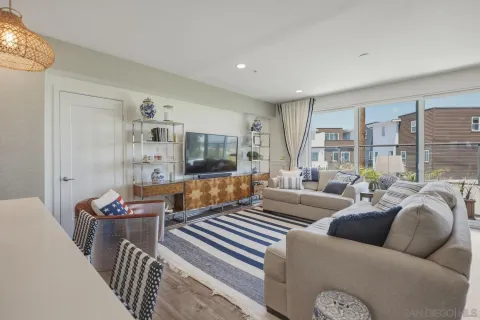 a living room with furniture a flat screen tv and a window