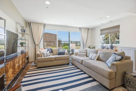 a living room with furniture a flat screen tv and a large window