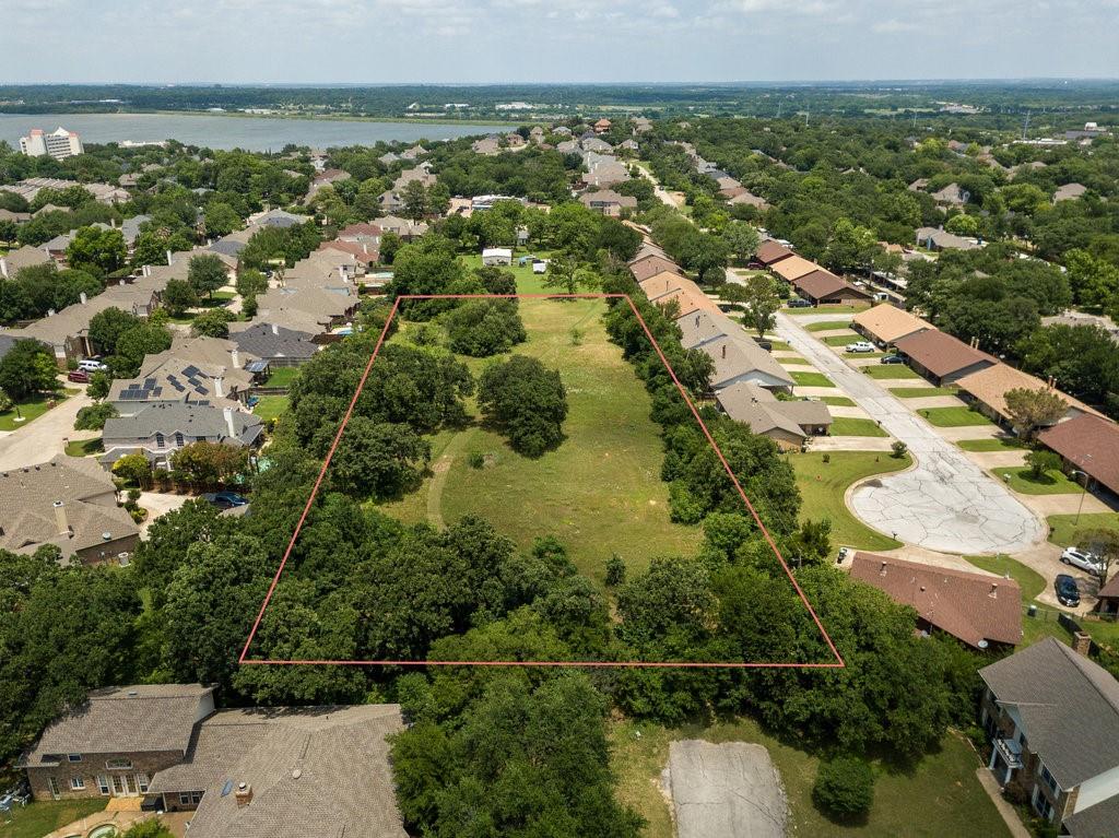 an aerial view of residential houses with outdoor space and trees