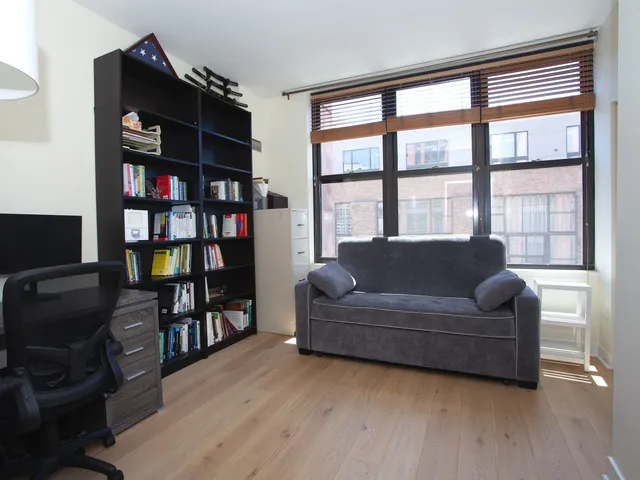 a living room with furniture and a book shelf