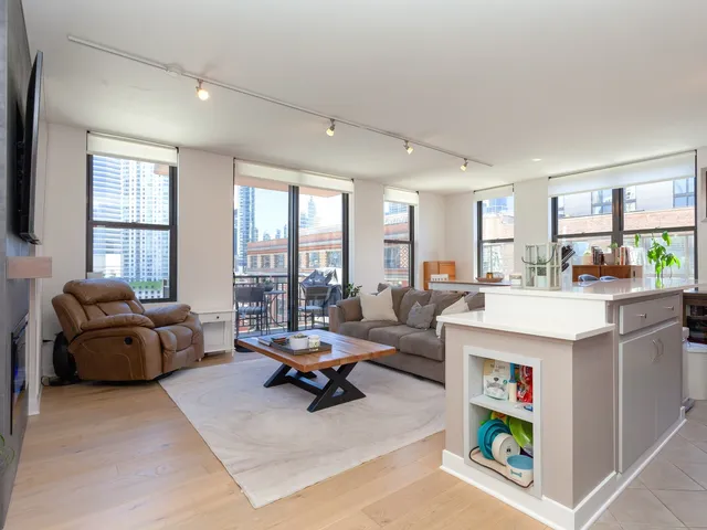 a living room with furniture and a open kitchen view