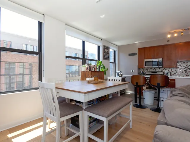 a living room with furniture a large window and kitchen view