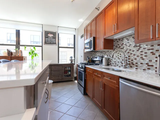a kitchen with kitchen island granite countertop a sink stove and cabinets