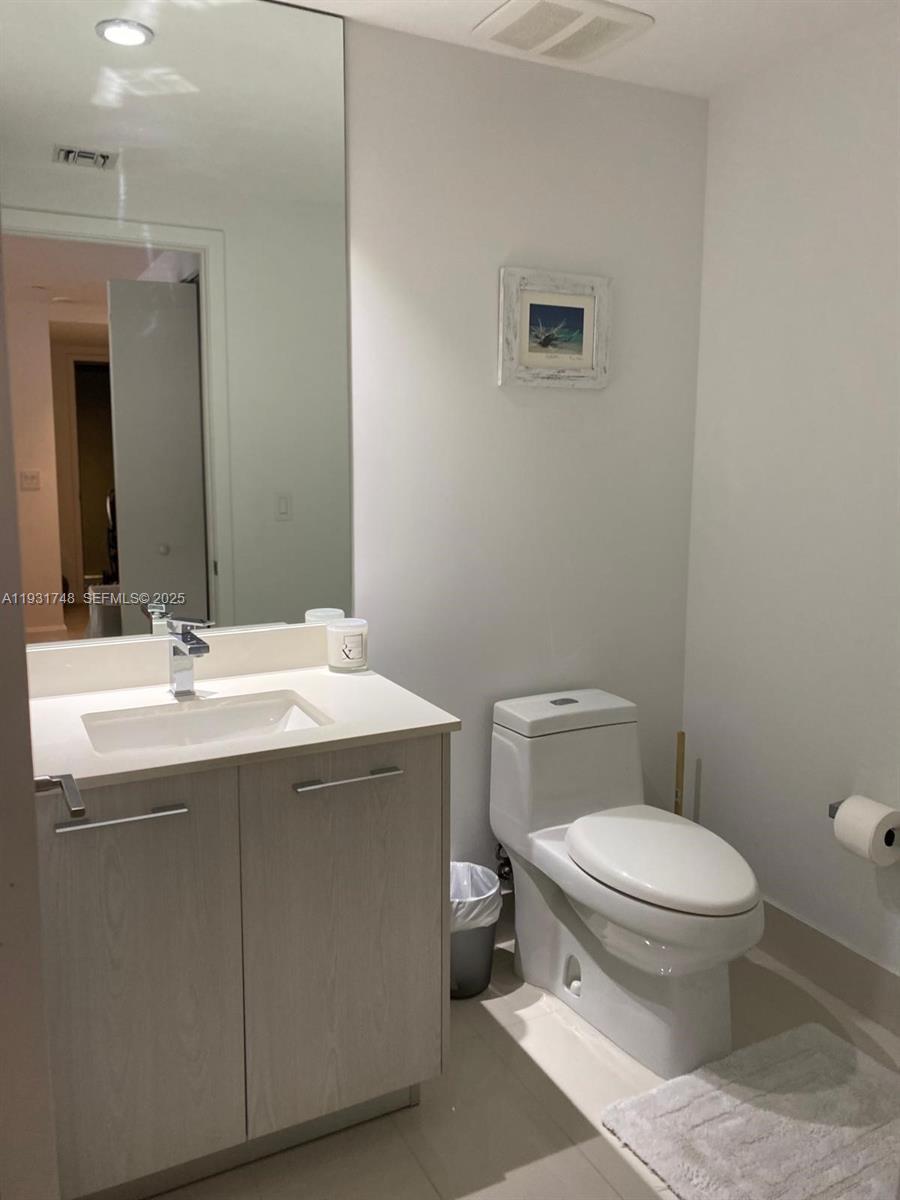 55 Southwest 9th Street, Unit 3609 Miami, FL 33130 - Photo 3 of 21 a bathroom with a sink toilet and mirror