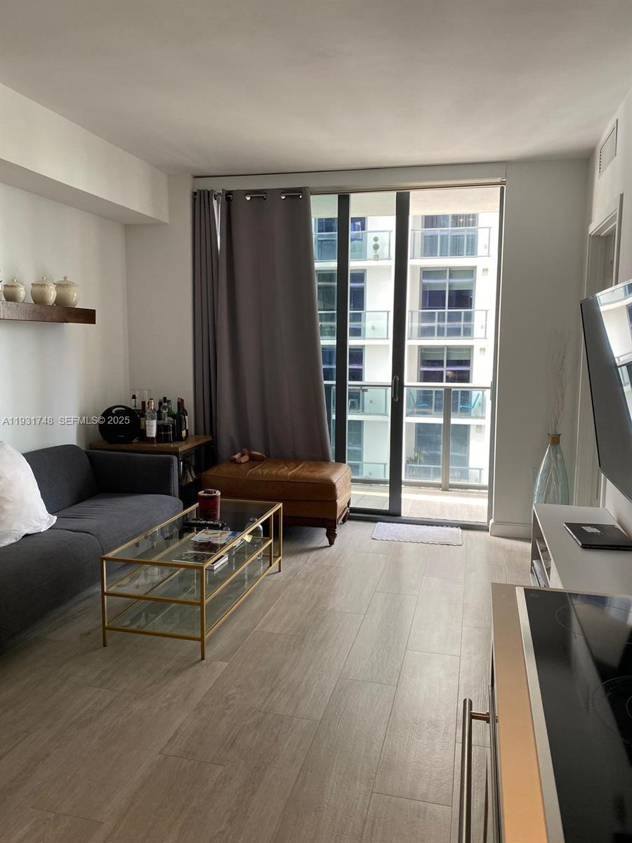 55 Southwest 9th Street, Unit 3609 Miami, FL 33130 - Photo 5 of 21 a living room with furniture and a flat screen tv