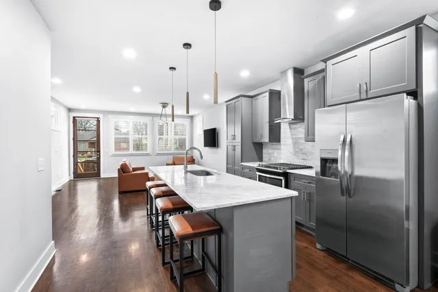 a kitchen with stainless steel appliances refrigerator dining table and chairs
