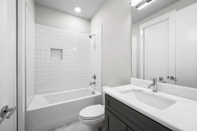 a bathroom with a granite countertop sink a toilet and shower