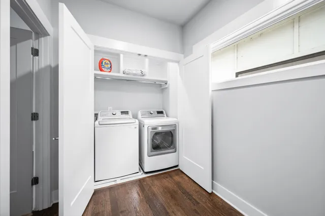 a utility room with wooden floor washer and dryer