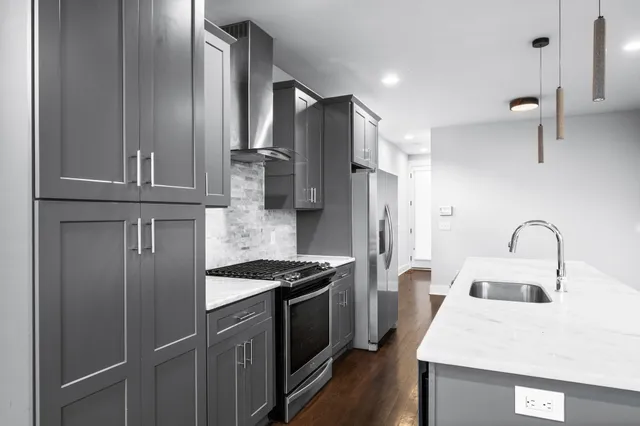 a kitchen with stainless steel appliances a refrigerator sink and stove