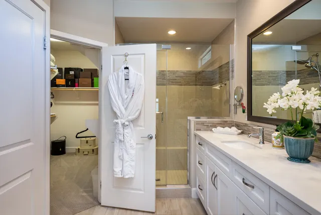 a bathroom with a double vanity sink toilet and shower