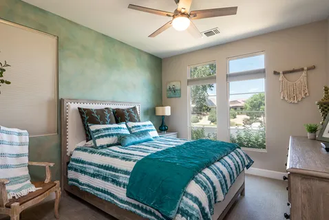 a bedroom with a large bed and windows