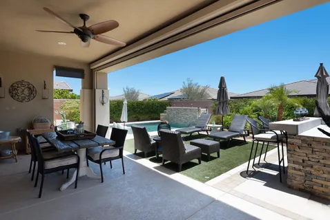a living room with patio furniture and a large window