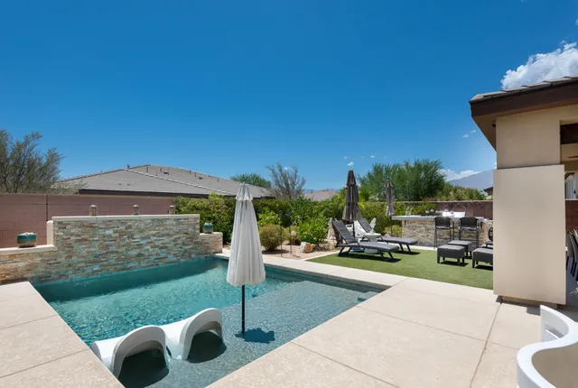 a view of a patio with couches chairs and a fire pit with some trees