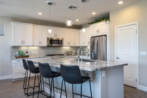 a kitchen with kitchen island granite countertop a center island cabinets and stainless steel appliances