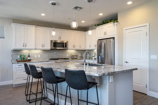 a kitchen with kitchen island granite countertop a center island cabinets and stainless steel appliances