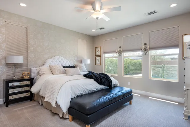 a spacious bedroom with a bed and a chandelier