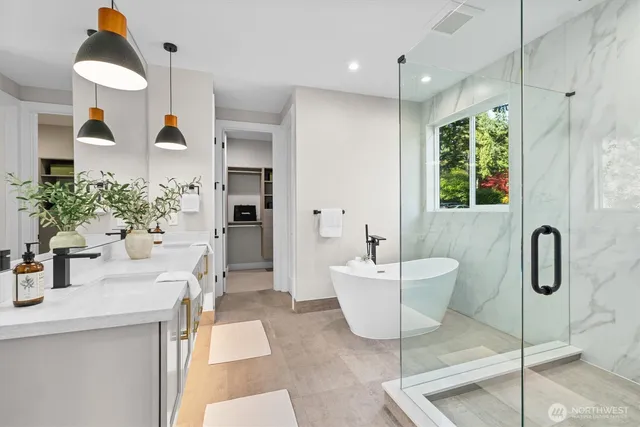 a bathroom with a sink and mirror with bathtub