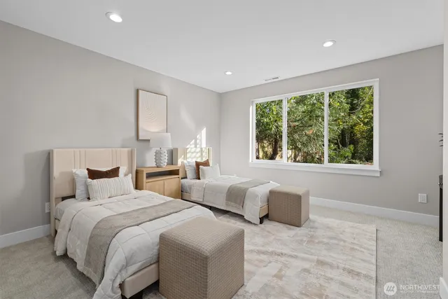 a bedroom with two beds and a large window