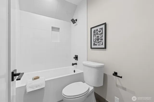 a white toilet sitting next to a bath tub