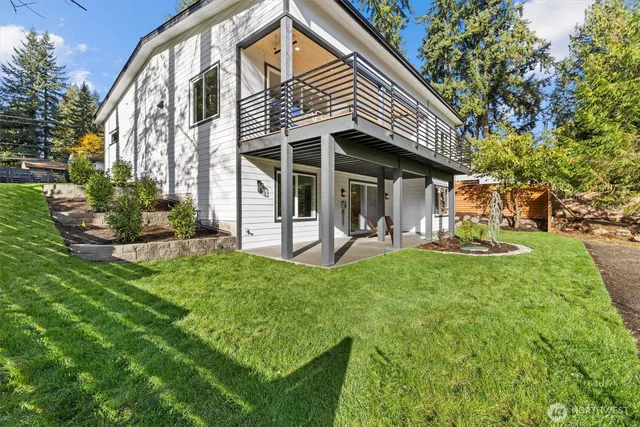 a view of a house with backyard and sitting area