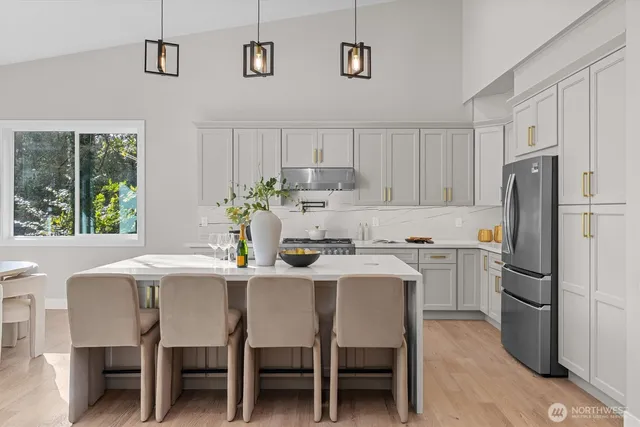 a kitchen with a dining table chairs and refrigerator