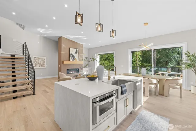 a kitchen that has a lot of white cabinets and stainless steel appliances