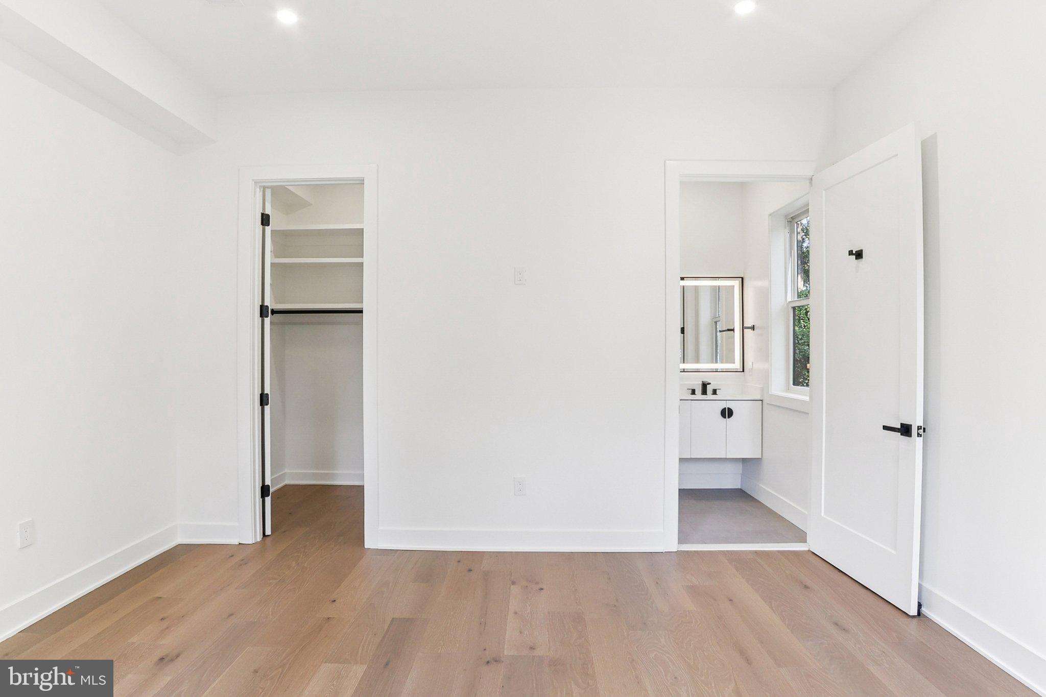 5419 Kempsville Street Springfield, VA 22151 - Photo 26 of 45 a view of an empty room with wooden floor and a bathroom