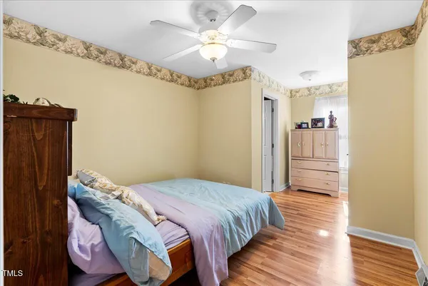a bedroom with a bed and wooden floor