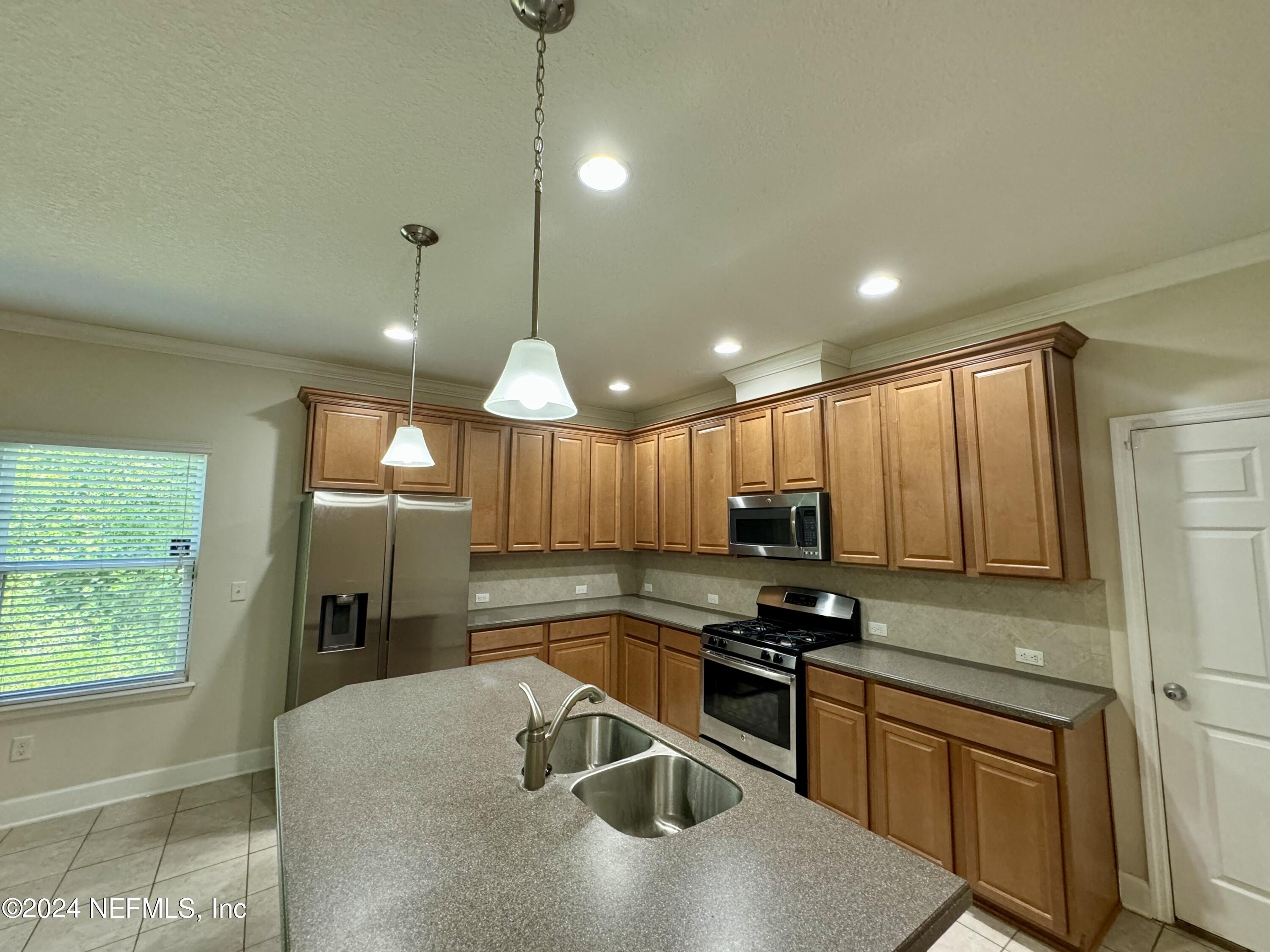 289 Spring Park Avenue Ponte Vedra, FL 32081 - Photo 3 of 19 a kitchen with stainless steel appliances granite countertop a sink a stove and a refrigerator