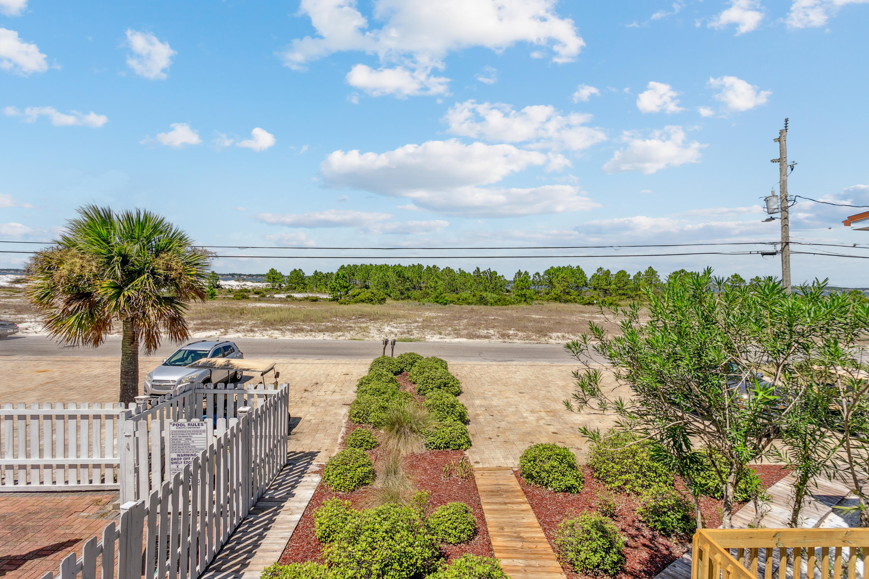 7905 White Sands Boulevard, Unit 2 Navarre, FL 32566 - Photo 12 of 51 a view of a lake with a floor to ceiling window next to a yard