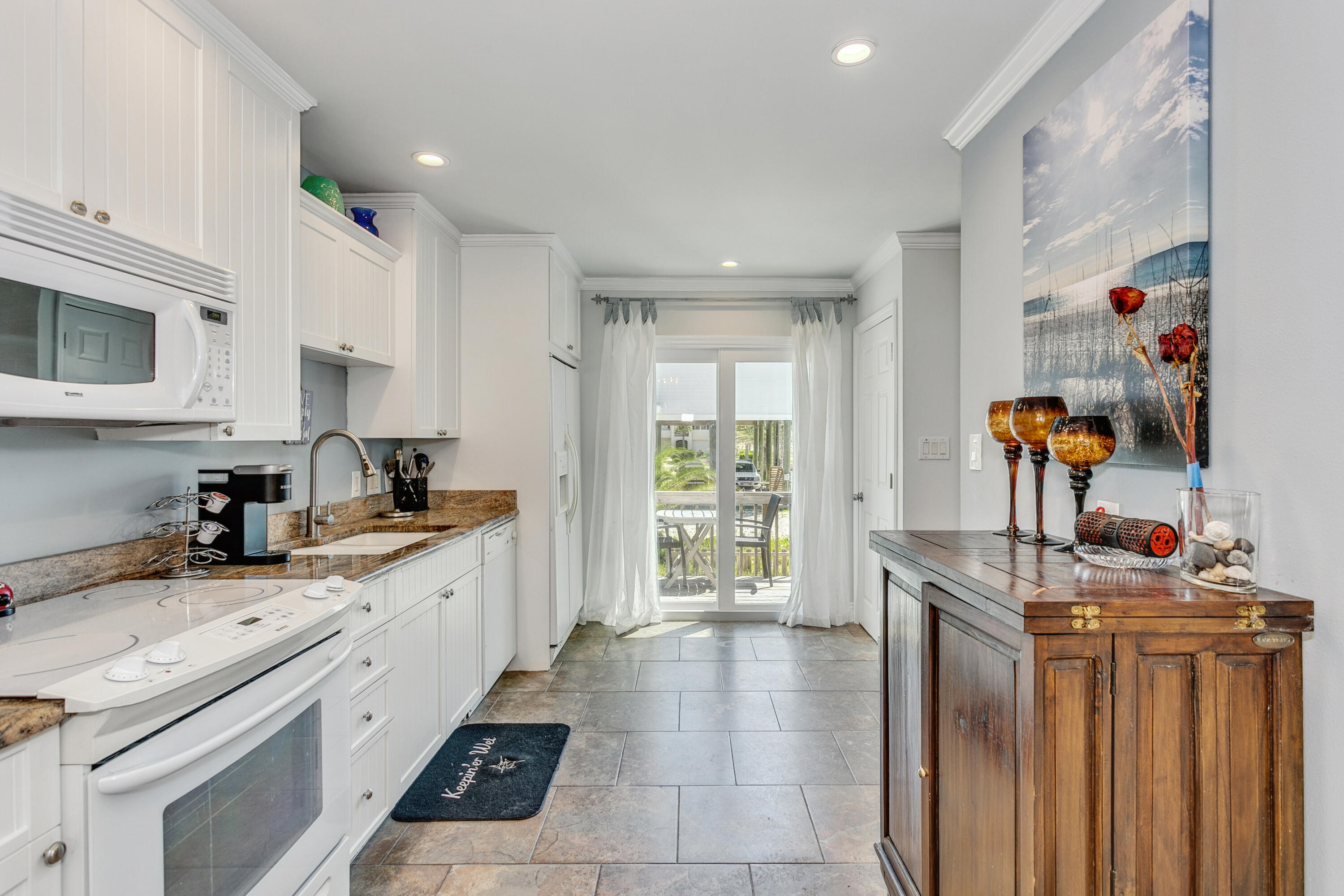 7905 White Sands Boulevard, Unit 2 Navarre, FL 32566 - Photo 18 of 51 a kitchen with stainless steel appliances granite countertop a sink stove and cabinets
