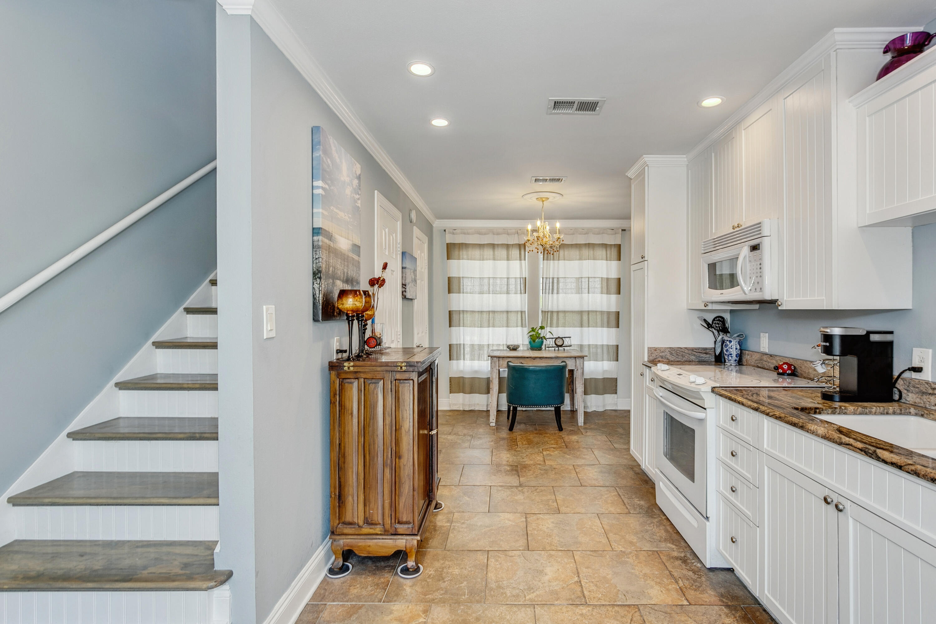 7905 White Sands Boulevard, Unit 2 Navarre, FL 32566 - Photo 21 of 51 a large white kitchen with stainless steel appliances granite countertop a stove and a sink