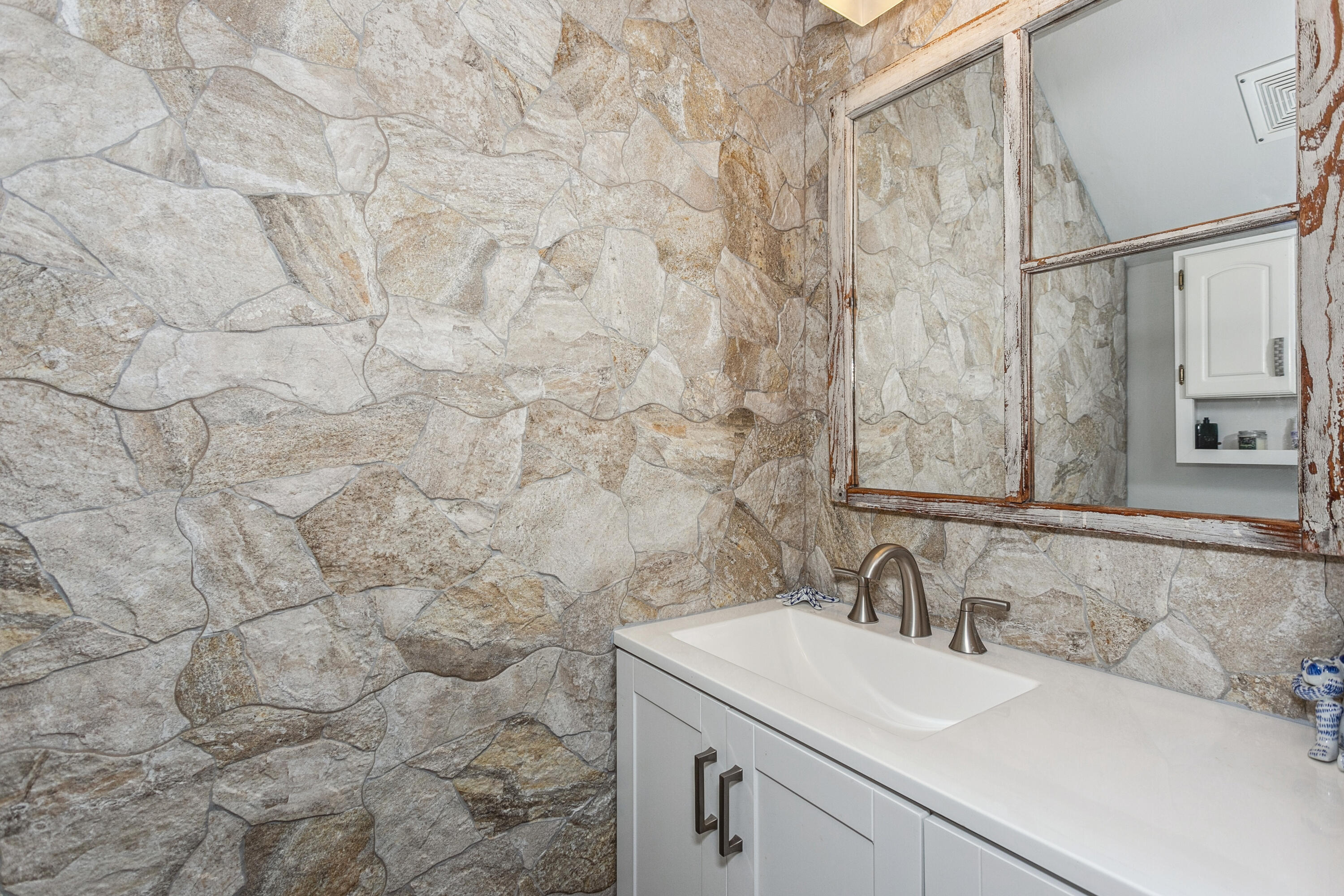 7905 White Sands Boulevard, Unit 2 Navarre, FL 32566 - Photo 23 of 51 a bathroom with a sink and a mirror
