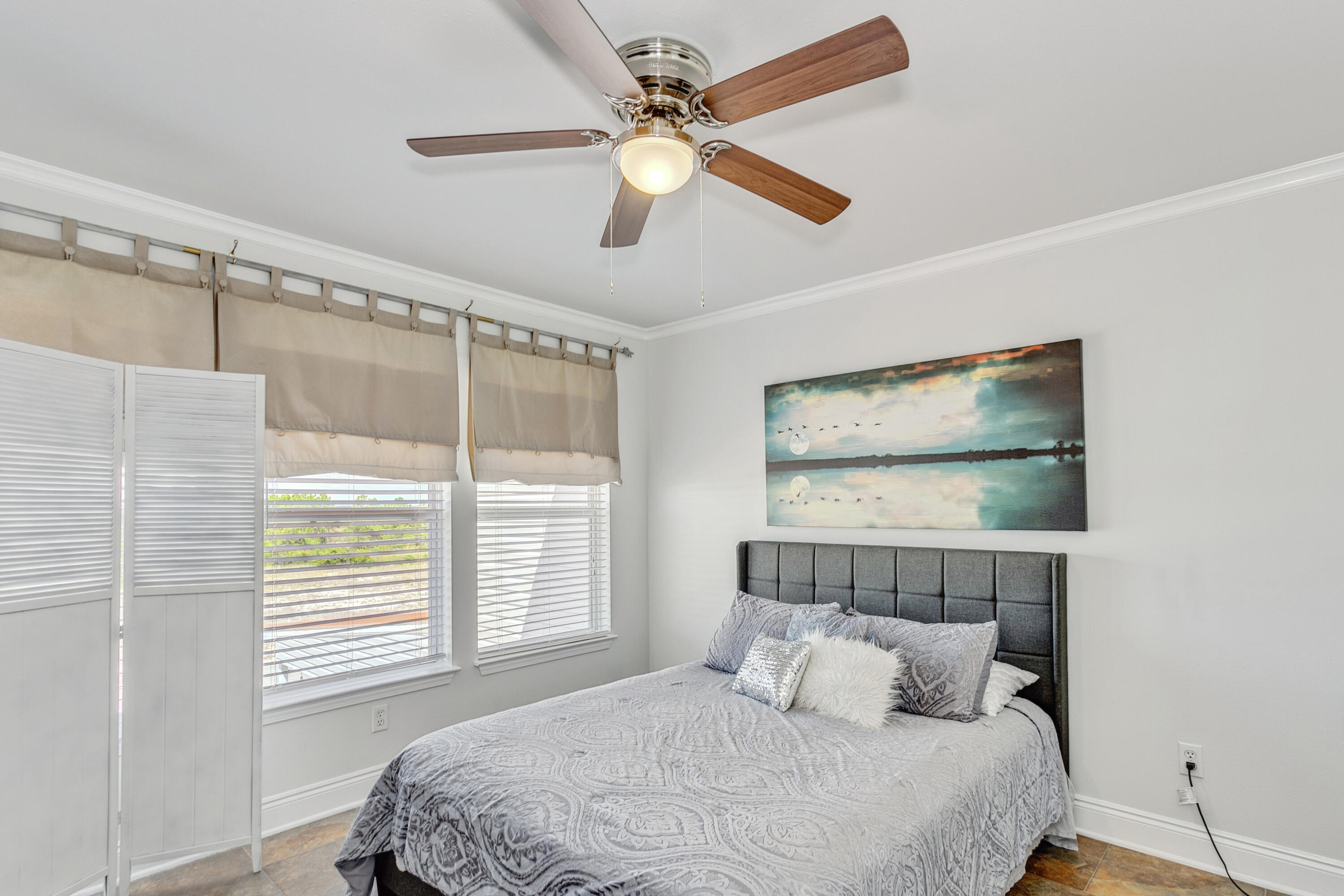 7905 White Sands Boulevard, Unit 2 Navarre, FL 32566 - Photo 24 of 51 a bedroom with a large bed and a chandelier