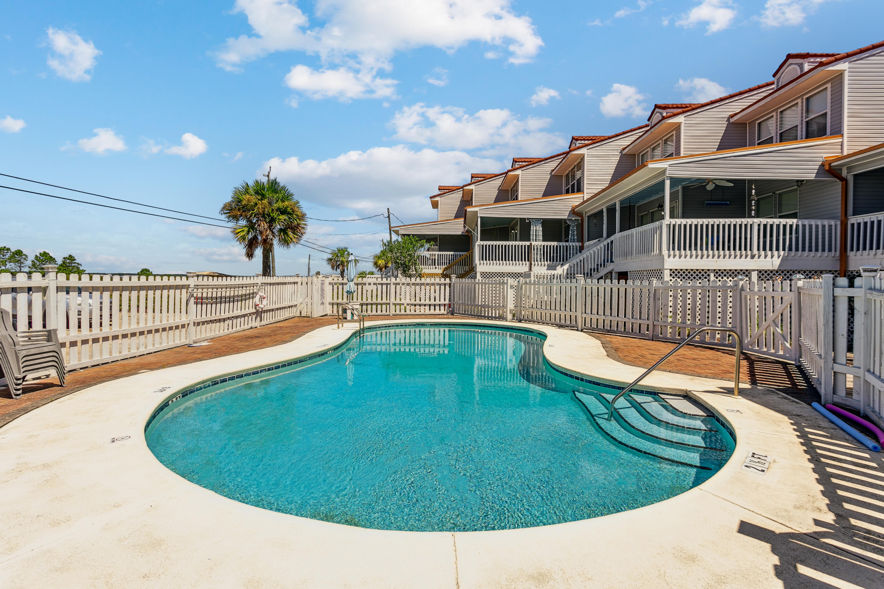 7905 White Sands Boulevard, Unit 2 Navarre, FL 32566 - Photo 40 of 51 a view of a swimming pool with a lounge chairs