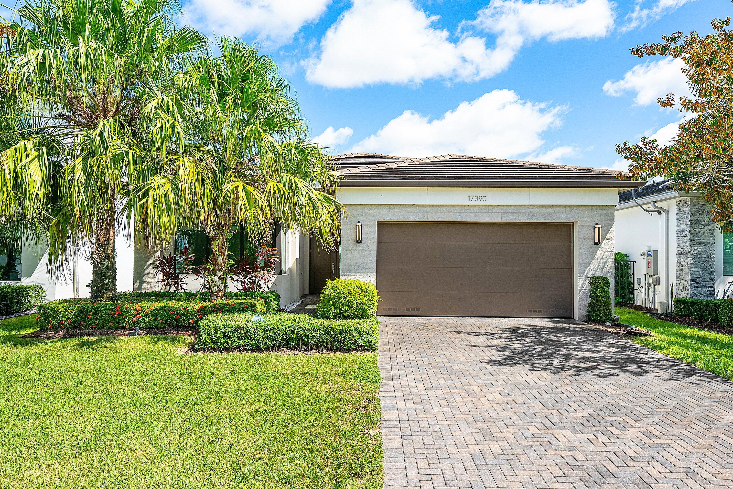 17390 Pagoda Palms Drive Boca Raton, FL 33496 - Photo 1 of 53 a front view of a house with a yard and garage
