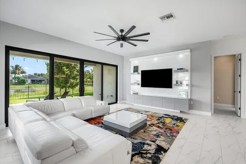 a living room with furniture a flat screen tv and a large window