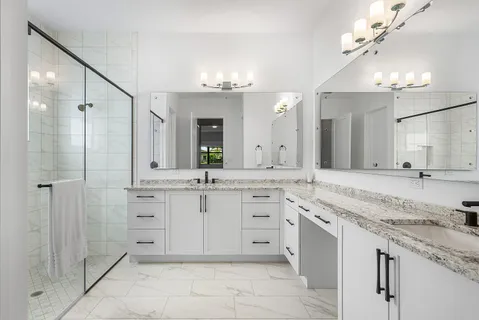 a spacious bathroom with a granite countertop sink a mirror a shower and a bathtub