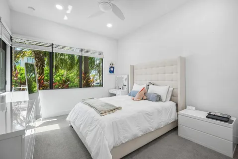 a bedroom with a bed and a large window