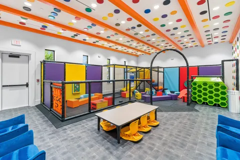 a living room with furniture and large windows