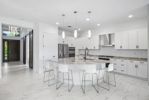 a kitchen with stainless steel appliances kitchen island granite countertop a sink and cabinets