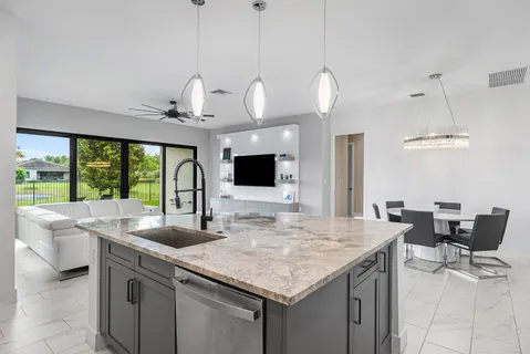 a kitchen with granite countertop a sink and chandelier