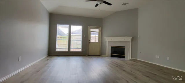 wooden floor fireplace and windows in an empty room