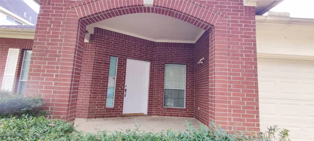 a front view of a building with a garden and plants