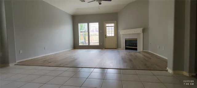 an empty room with windows and fireplace