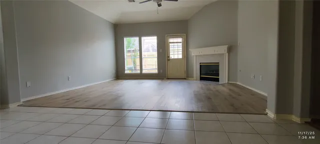 an empty room with windows and fireplace