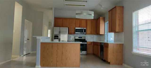 a kitchen with stainless steel appliances a refrigerator and a stove top oven
