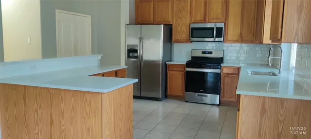 a kitchen with stainless steel appliances a refrigerator a stove a microwave and sink