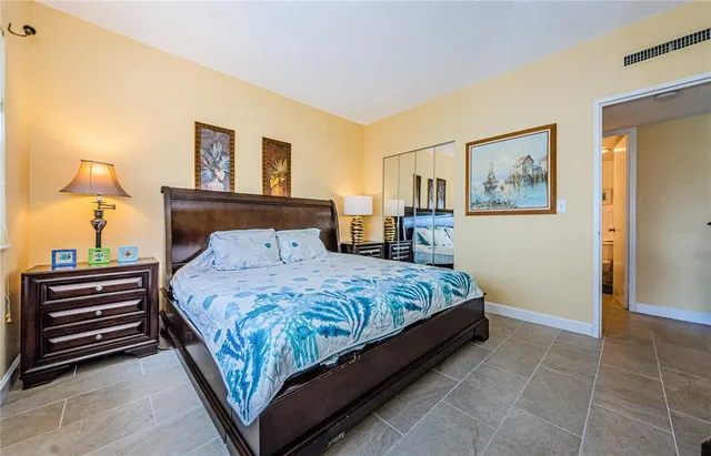 a bedroom with a bed and dresser with mirror